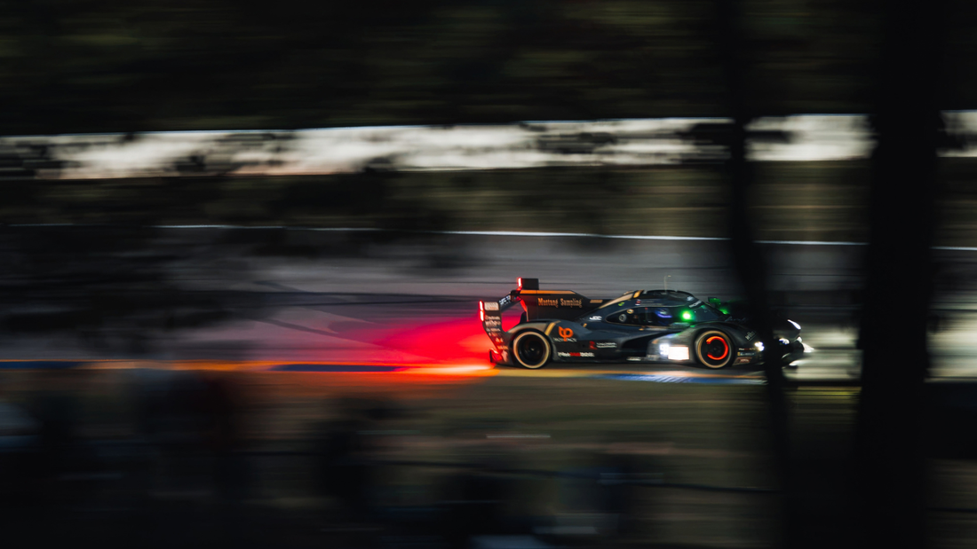 Race car competing at night during Petit Le Mans at Michelin Raceway Road Atlanta.