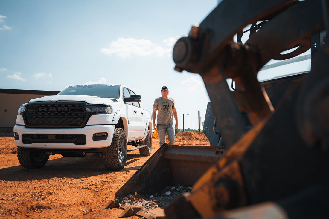 Dustin Jones next to a white Rocky Ridge Ram truck in a construction scene.
