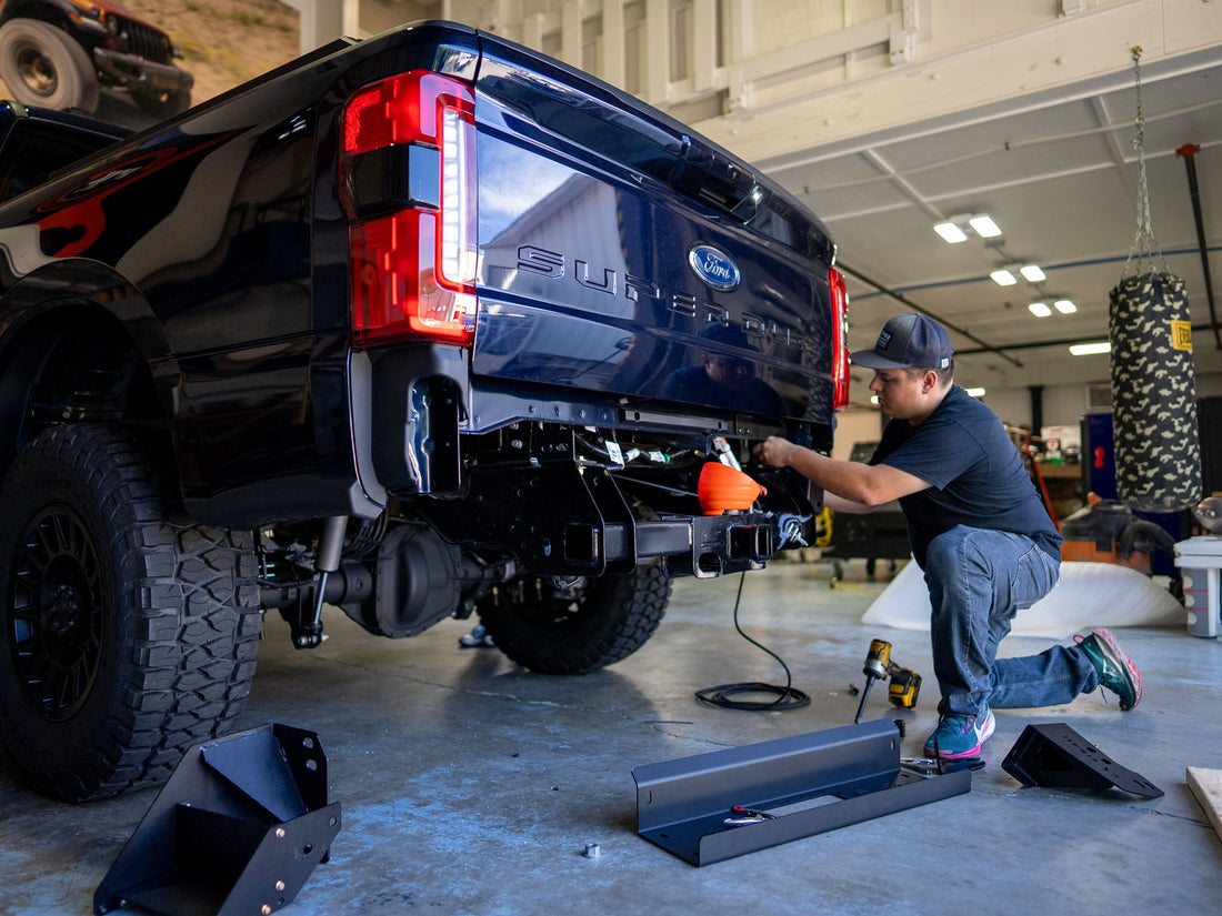 Factory builder installing a part on a Rocky Ridge Super Duty truck