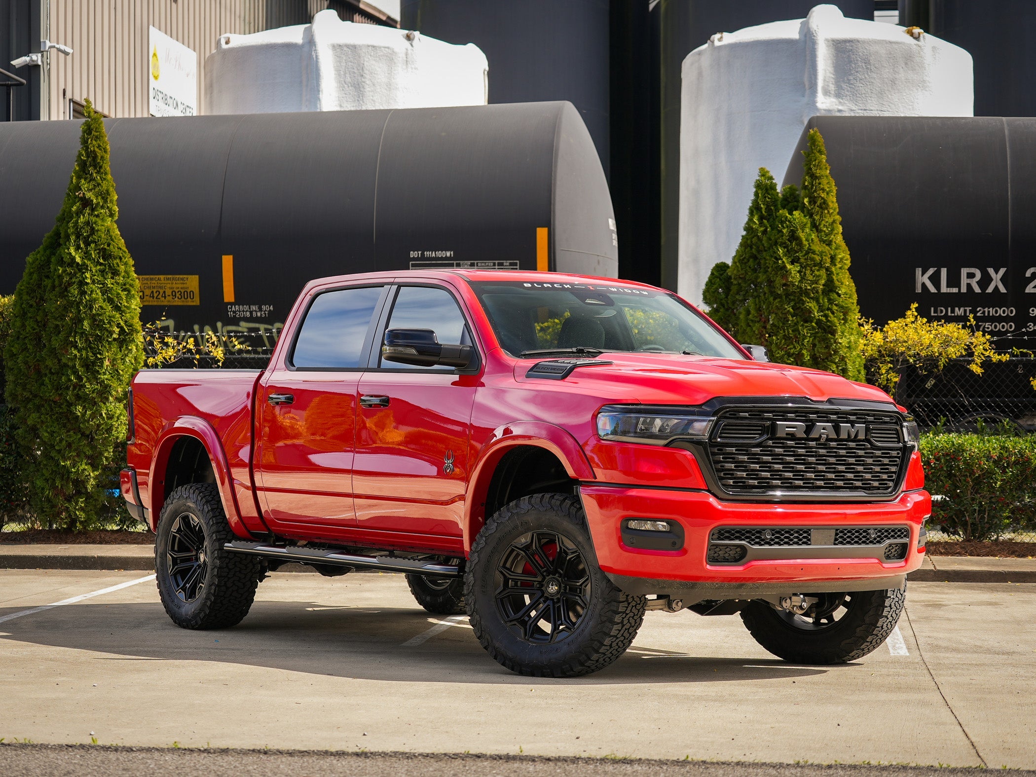 Red Black Widow Ram parked in an industrial scene.