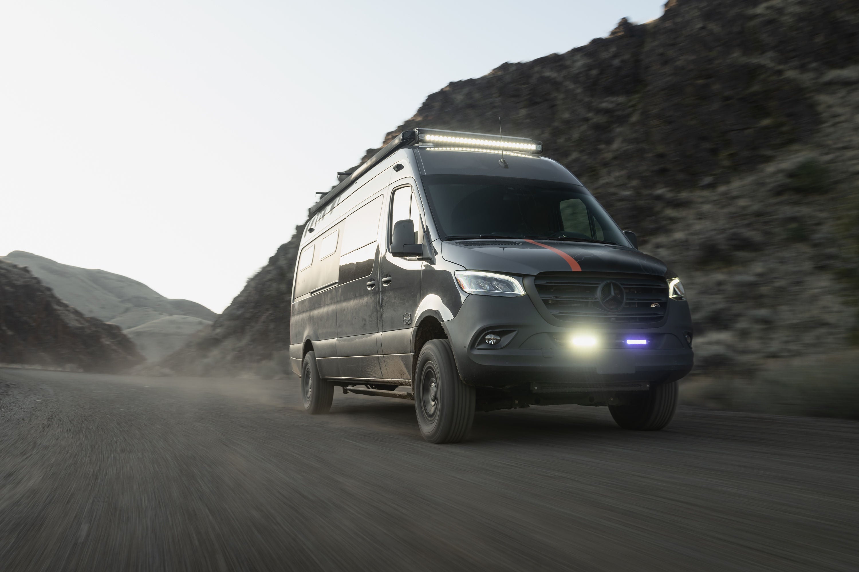 Outside Van sprinter van driving through a mountain pass on a dirt road