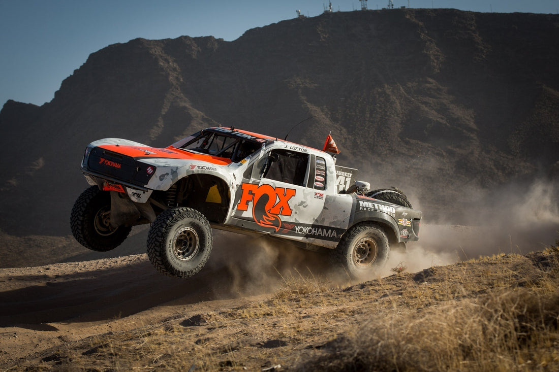 Baja Race Truck driver Justin Lofton barreling over a hill in his FOX sponsored race truck