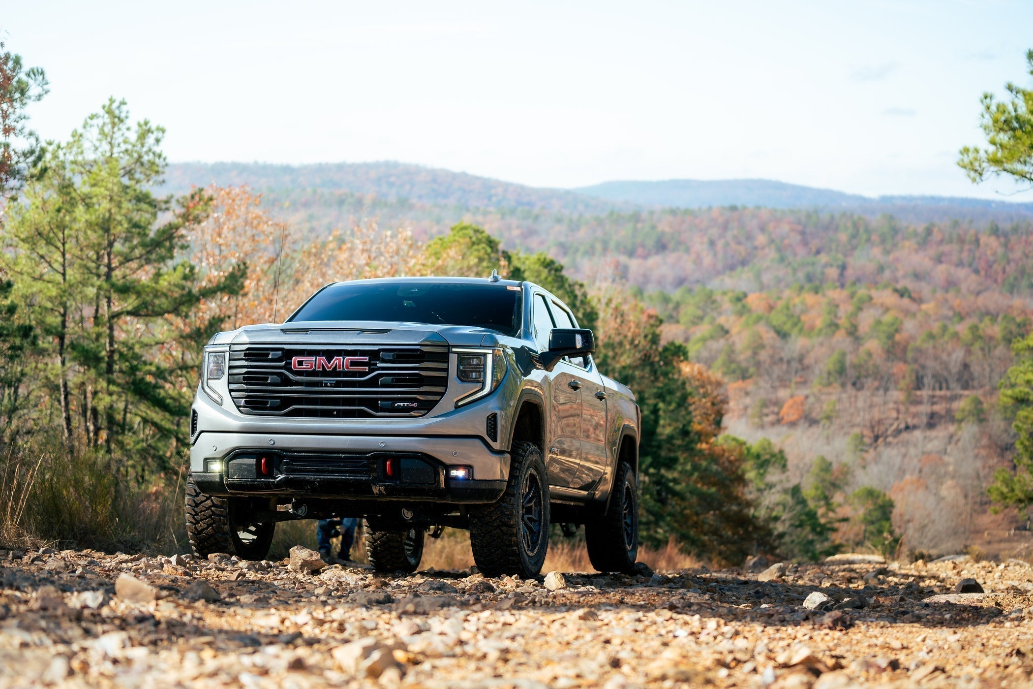 GMC Sierra in a mountain scene during the Fall season with autumn foliage.