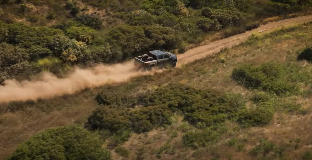 Fox Factory truck barreling down a dirt road kicking up dust.