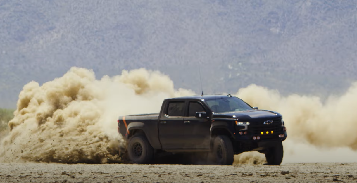 Fox Factory Silverado 1500 sliding in the desert dirt, kicking up dust.