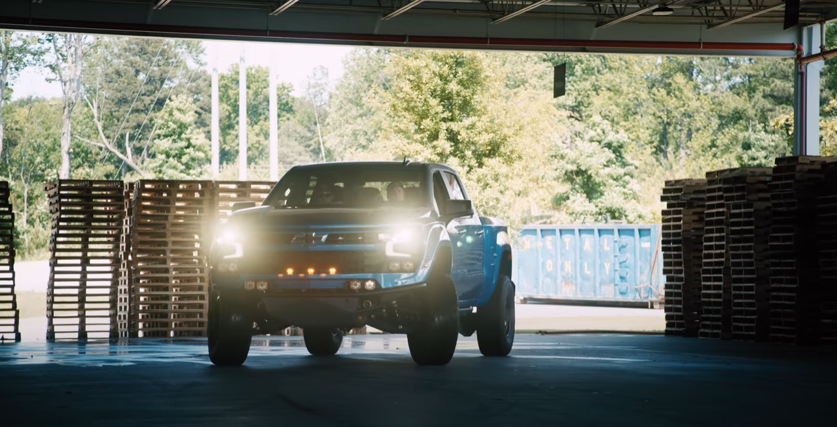 Fox Factory Silverado in Riptide Blue sliding out of the warehouse aggressively.